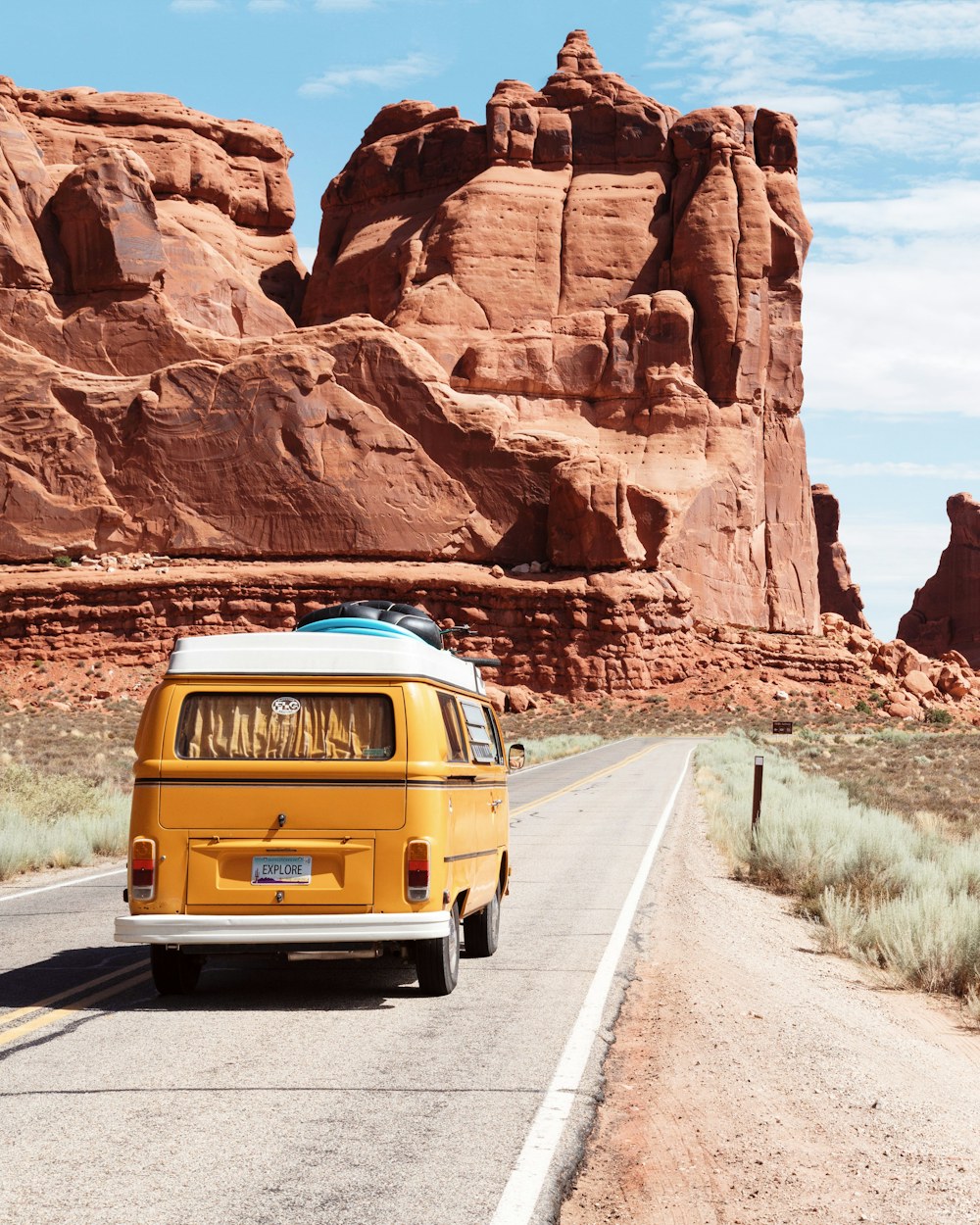 Kombi amarela viajando por uma estrada de montanha
