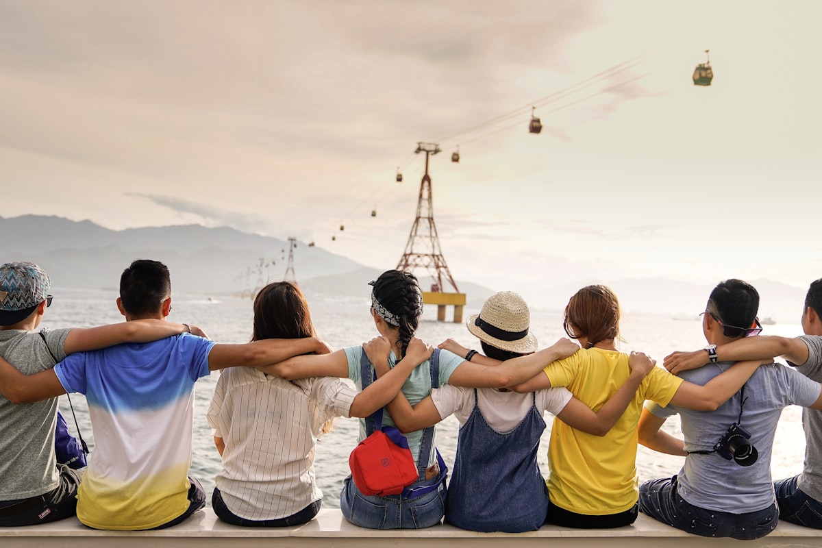 Grupo de amigos abraçados olhando o mar